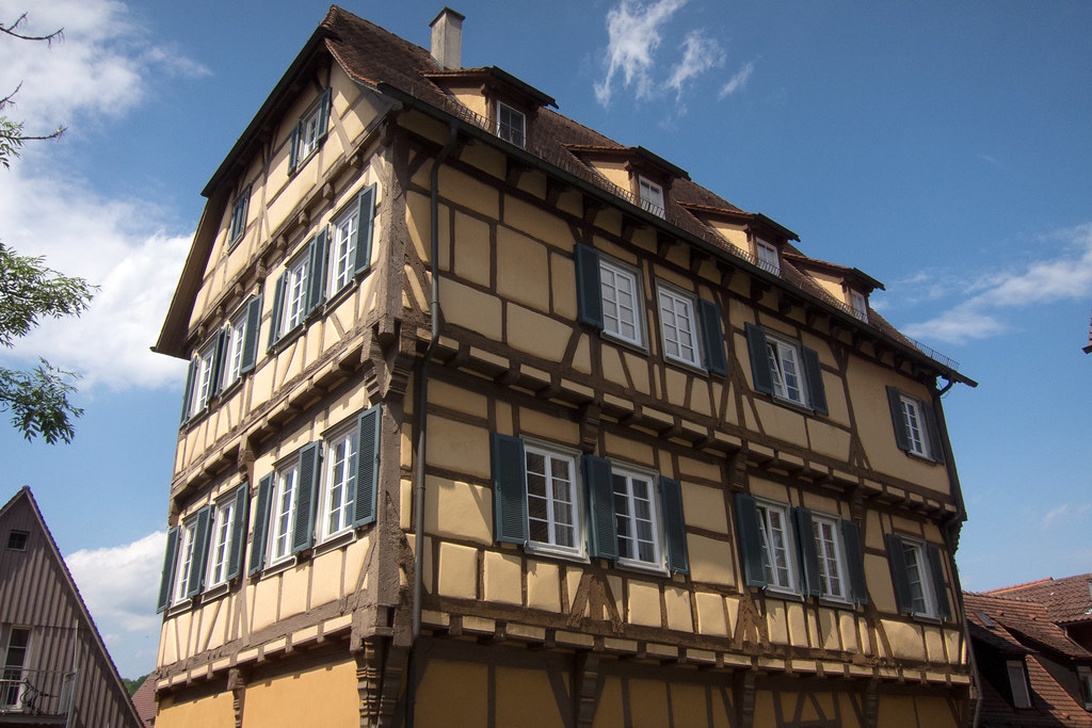Ein gut erhaltenes deutsches Fachwerkhaus mit sichtbaren Holzbalken und grünen Fensterläden.